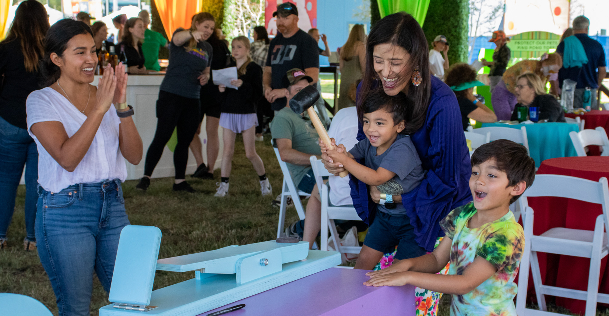 A family has fun playing a Carnival game at the event the year prior. 