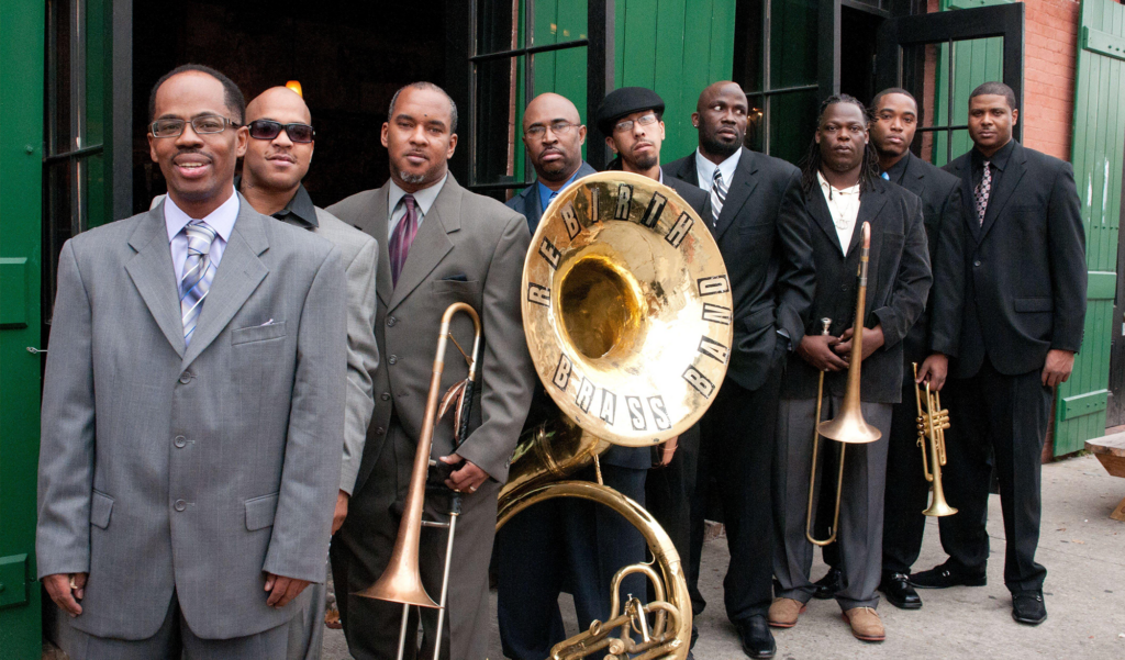 Rebirth Brass Band posed for a photo with their 9 members and two brass instruments